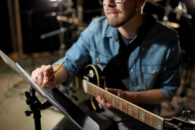 Músico componiendo con guitarra eléctrica en estudio de grabación