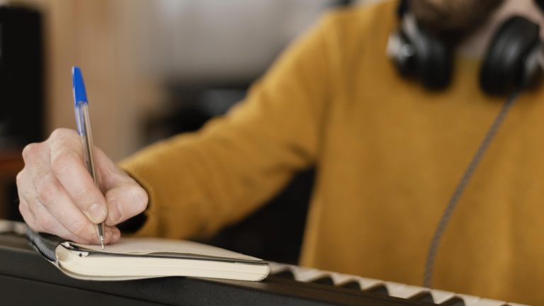 Músico escribiendo notas en estudio de grabación